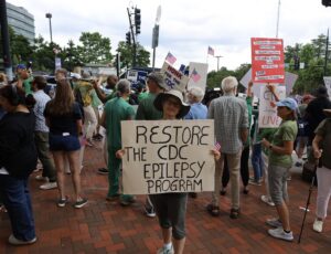 Rosemarie Kobau at CDC holding signs - Restore the CDC Epilepsy Program